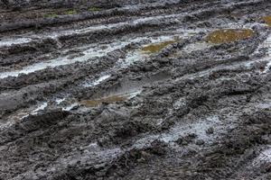 zwart nat aarde weg met plassen van vuil water Bij dag licht foto