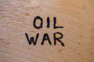 de woorden olie oorlog handgeschreven Aan vlak kaal multiplex oppervlakte met hout brander foto