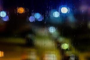 een abstract achtergrond nacht straat lichten bokeh door nat glas, detailopname met selectief focus foto