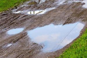 plas in aarde weg Bij zomer daglicht - detailopname met selectief focus, diagonaal samenstelling foto