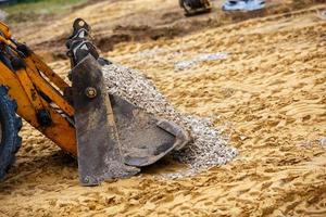 wiel bulldozer emmer gevulde met grind foto