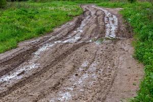 vuil weg met plassen en band sporen - detailopname met selectief focus foto