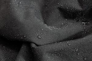 donker grijs waterbestendig hydrofoob kleding detailopname met regen druppels foto