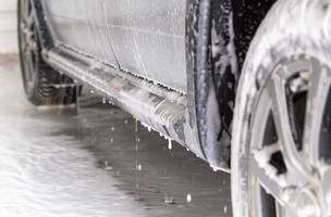 detailopname visie van zilver auto stap Bij carwash met zeep sud vlekken en druppels foto
