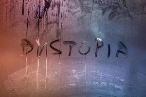 de woord dystopie handgeschreven Aan nat venster glas oppervlakte foto