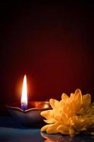 gelukkig divali. traditioneel symbolen van Indisch festival van licht. brandend diya olie lampen en bloemen Aan rood achtergrond. foto