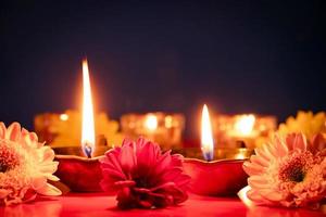 gelukkig divali. brandend diya olie lampen en bloemen Aan blauw achtergrond. traditioneel Indisch festival van licht. foto