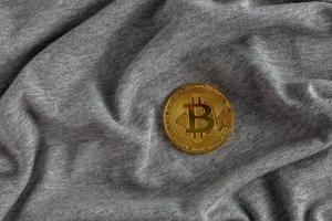 gouden bitcoin glans Aan grijs verfrommeld katoen kleding foto