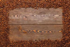 rechthoekig kader van veel geroosterd koffie bonen Aan bruin houten oppervlakte foto