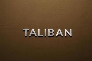 de woord taliban gelegd met zilver metaal brieven Aan ruw bruinen khaki canvas kleding stof foto