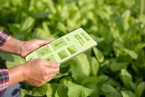 landbouw technologie boer Holding digitaal tablet of tablet technologie naar Onderzoek over landbouw problemen analyse gegevens en zichtbaar icoon. slim landbouw boer gebruik makend van internet van dingen foto