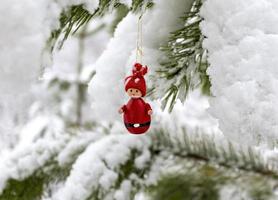 Kerstmis decoraties Kerstmis boom speelgoed- rood gnoom hangende Aan een met sneeuw bedekt pijnboom Afdeling in de winter Woud. foto