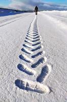 Mens van achter maken een spoor in de sneeuw, schoen prints in de sneeuw foto