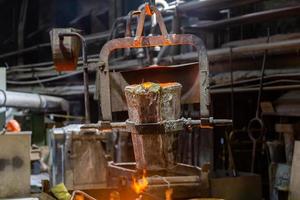 klein metallurgisch pollepel met gesmolten staal beweegt Aan een haak van kraan foto