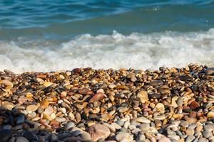 zee kust met ronde stenen Aan de middellandse Zee kust. horizontaal afbeelding. foto