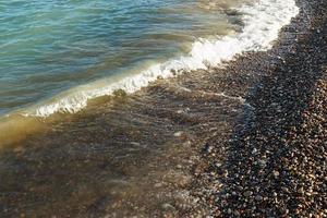 zee kust met ronde stenen Aan de middellandse Zee kust. horizontaal afbeelding. foto