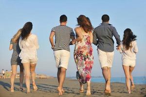 gelukkig jong mensen groep hebben pret Aan strand foto