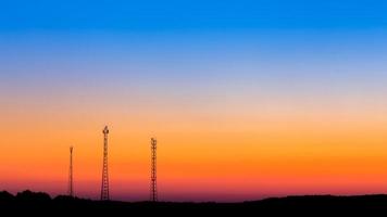 communicatie torens ver Aan zonsopkomst lucht achtergrond foto