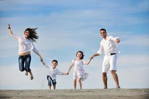 gelukkig jong familie hebben pret Aan strand foto