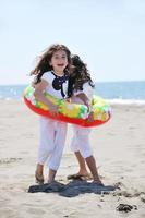 gelukkig kind groep spelen op strand foto