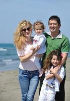 gelukkig jong familie hebben pret Aan strand foto