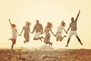 gelukkig jong mensen groep hebben pret Aan strand foto