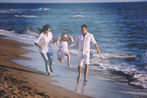 gelukkig jong familie hebben pret Aan strand foto