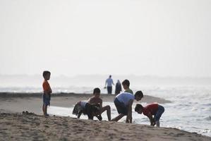 kinderen hebben pret Aan strand Bij vroeg ochtend- foto