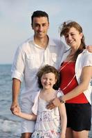 gelukkig jong familie hebben pret Aan strand foto