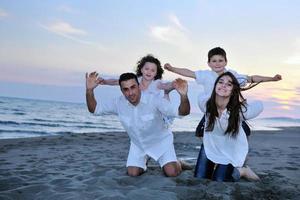 gelukkig jong familie hebben pret Aan strand foto