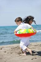 gelukkig kind groep spelen op strand foto