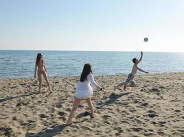 jong mensen groep hebben pret en Speel strand volleybal foto