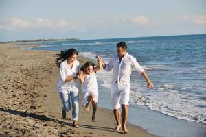 gelukkig jong familie hebben pret Aan strand foto