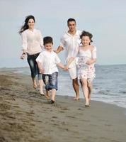 gelukkig jong familie hebben pret Aan strand foto