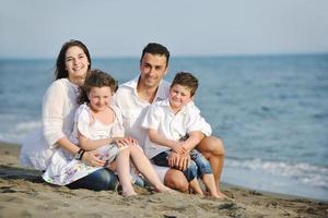 gelukkig jong familie hebben pret Aan strand foto