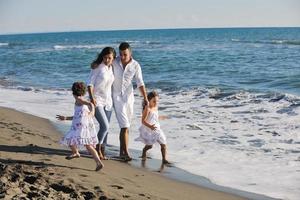 gelukkig jong familie hebben pret Aan strand foto