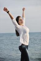 jong vrouw genieten Aan strand foto