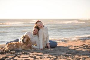 paar met hond genieten van tijd Aan strand foto