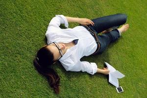 jonge vrouw die een boek in het park leest foto