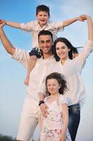 gelukkig jong familie hebben pret Aan strand foto