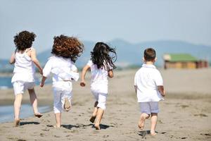 gelukkig kind groep spelen op strand foto