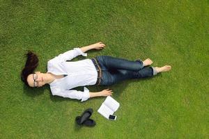 jonge vrouw die een boek in het park leest foto