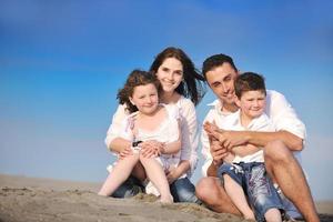 gelukkig jong familie hebben pret Aan strand foto