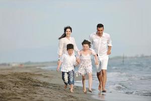 gelukkig jong familie hebben pret Aan strand foto