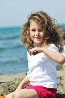 klein vrouwelijk kind portret op het strand foto