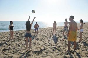 jong mensen groep hebben pret en Speel strand volleybal foto