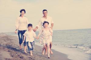 gelukkig jong familie hebben pret Aan strand foto