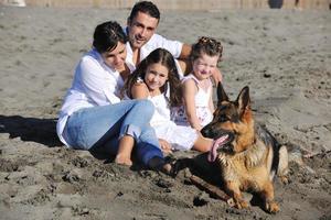 gelukkig familie spelen met hond Aan strand foto