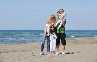 gelukkig jong familie hebben pret Aan strand foto