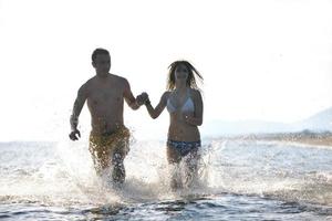 gelukkig jong koppel veel plezier op het strand foto